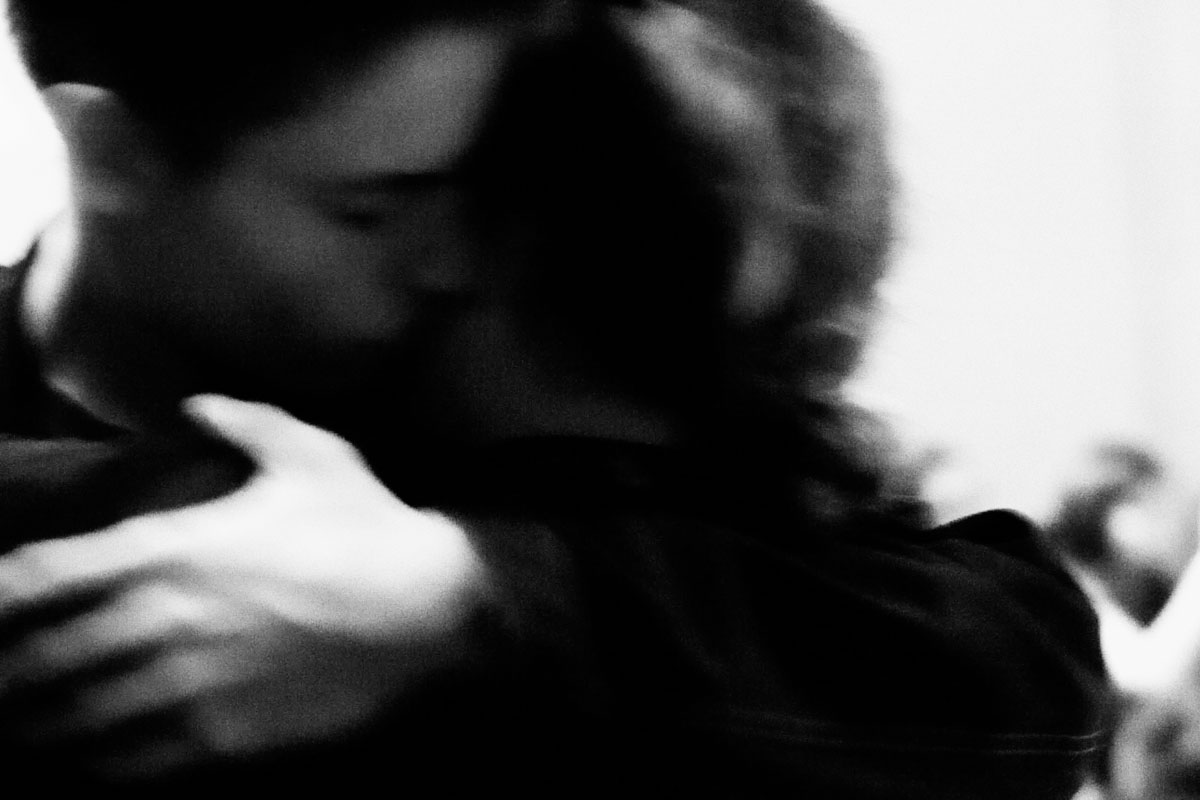 Two people embracing, blurred by movement.